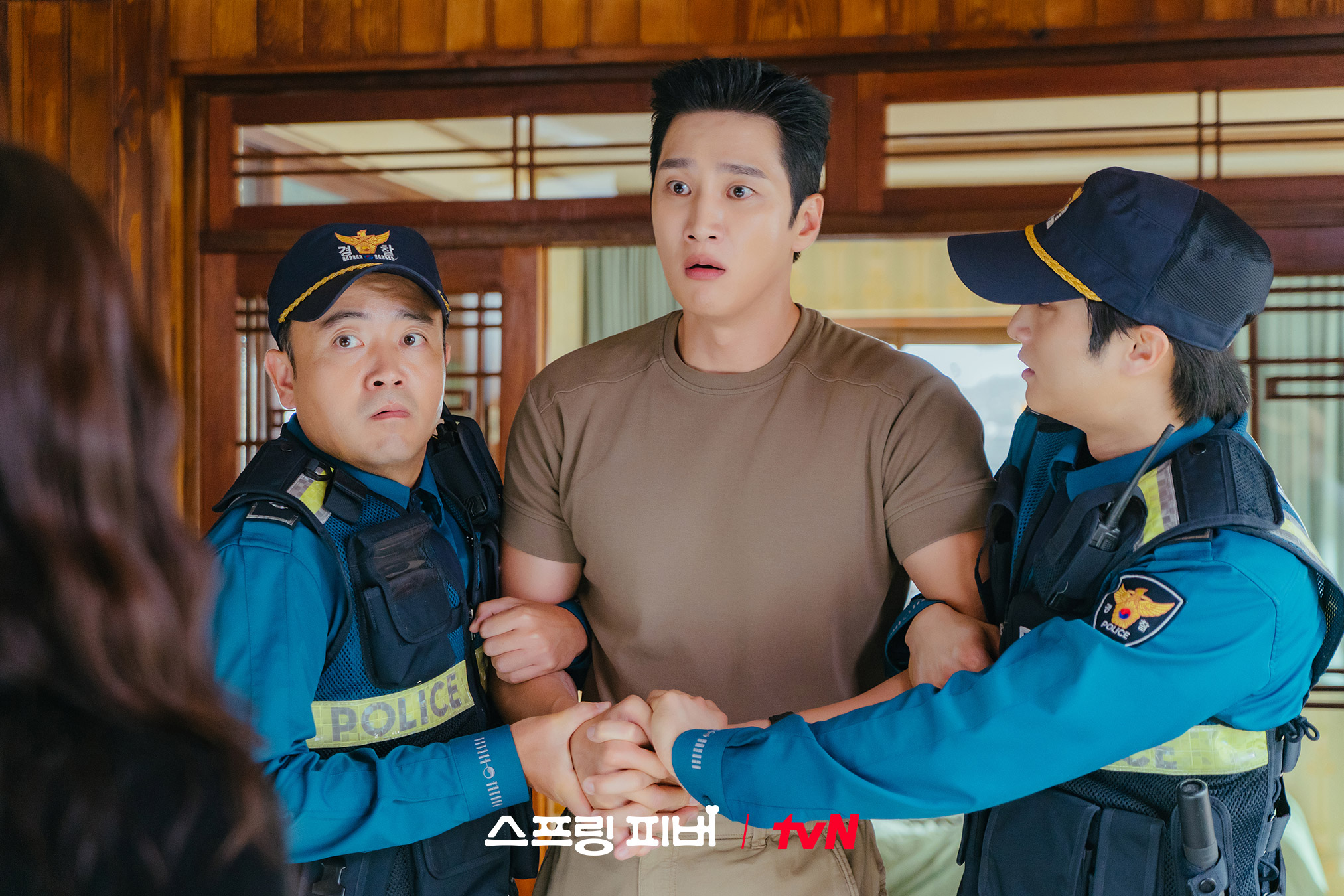 يُقتاد آهن بو هيون من قبل الشرطة بينما تشاهد لي جو بين المشهد في حالة صدمة في مسلسل "حمى الربيع - Spring Fever"