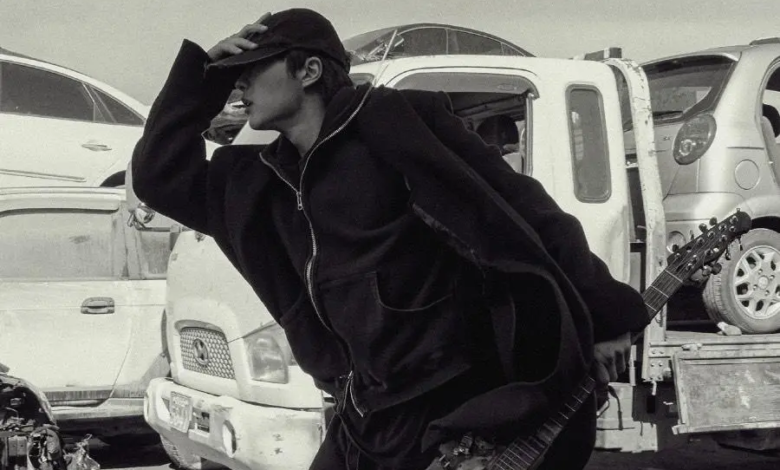 المغني WOODZ يفرّ يائساً حاملاً غيتاراً ملعوناً في ملصق جديد لفيلم قصير غامض بعنوان "Slide Strum Mute"